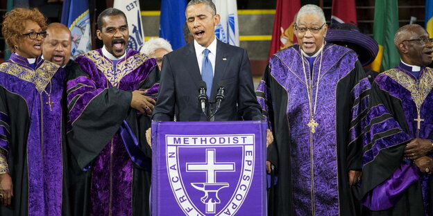 Barack Obama an einer Kanzel, hinter ihm Pastoren Barack Obama an einer Kanzel, hinter ihm Pastoren