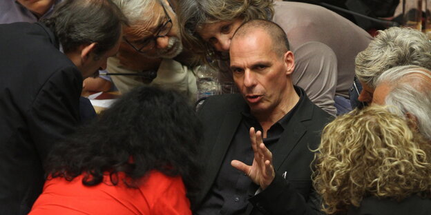 Der griechische Finanzminister Jannis Varoufakis umgeben von Parlamentsmitgliedern. Der griechische Finanzminister Jannis Varoufakis umgeben von Parlamentsmitgliedern.