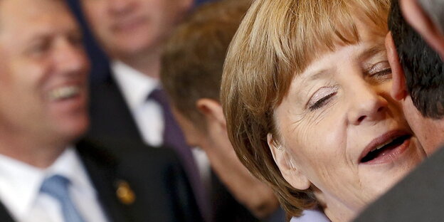 Bundeskanzlerin Angela Merkel flüstert einem Mann etwas ins Ohr. Bundeskanzlerin Angela Merkel flüstert einem Mann etwas ins Ohr.