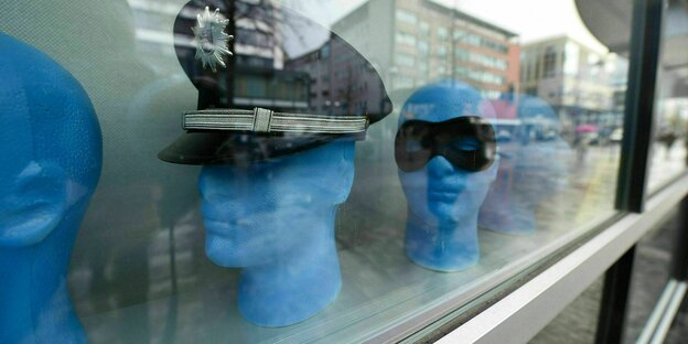 Polizeimütze und Verbrecher-Maske im Schaufenster.