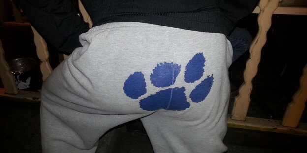 Ein Mann trägt eine Hose mit einer Tatze drauf Ein Mann trägt eine Hose mit einer Tatze drauf
