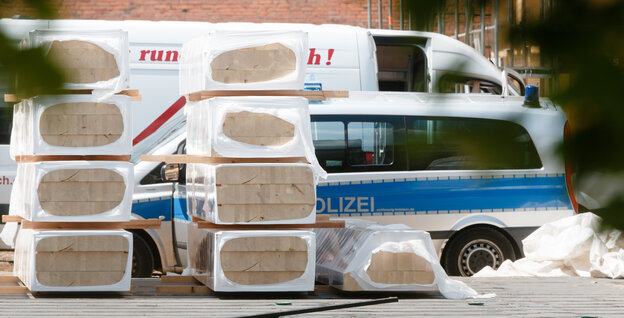 Ein Polizeiwagen steht zwischen Ziegelsteinen. Ein Polizeiwagen steht zwischen Ziegelsteinen.