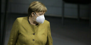 Angela Merkel trägt eine Maske und blickt zur Seite