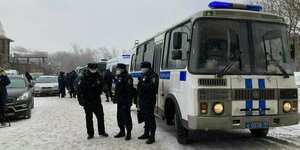 Russische Polizisten stehen neben ihrem Bus