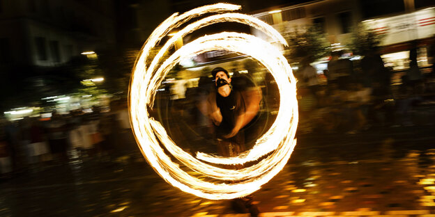 Artist jongliert mit Feuerstäben Artist jongliert mit Feuerstäben