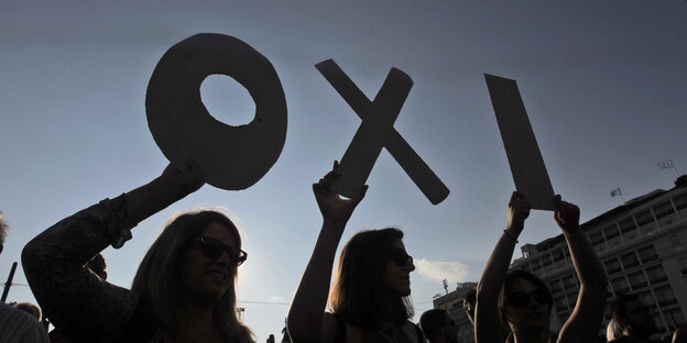 Vor der Abendsonne halten Menschen die Buchstaben des griechischen Wortes Oxi hoch Vor der Abendsonne halten Menschen die Buchstaben des griechischen Wortes Oxi hoch