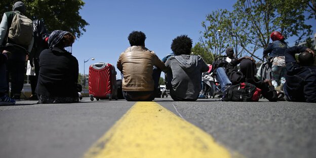 Menschen sitzen auf einer Straße Menschen sitzen auf einer Straße