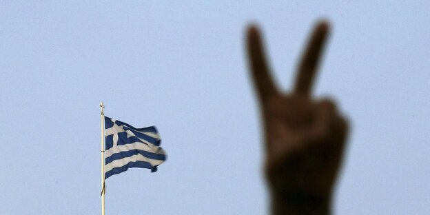 Eine Hand macht das Victory-Zeichen, im Hintergrund die griechische Fahne Eine Hand macht das Victory-Zeichen, im Hintergrund die griechische Fahne