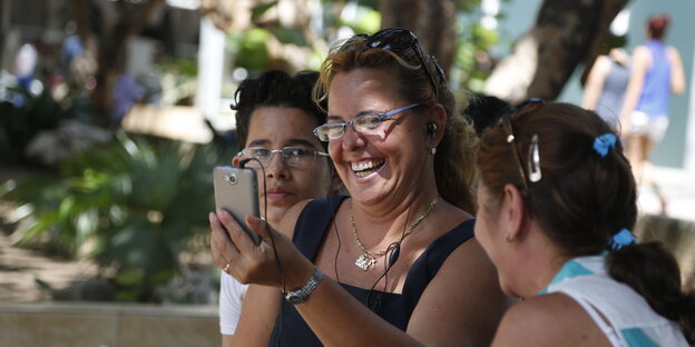 Menschen in Havanna betrachten ein Handy Menschen in Havanna betrachten ein Handy