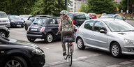 Radfahrerin bahnt sich den Weg durch parkende Autos