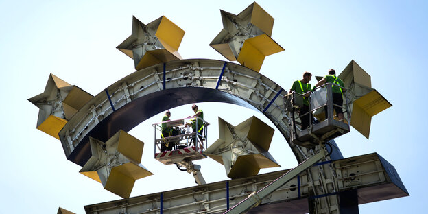 Arbeiter demontieren einen Stern von der Euro-Skulptur in Frankfurt Arbeiter demontieren einen Stern von der Euro-Skulptur in Frankfurt
