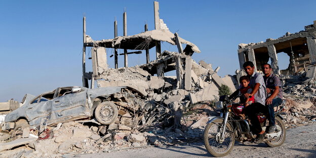 Männer aus Kobane vor einer Hausruine Männer aus Kobane vor einer Hausruine