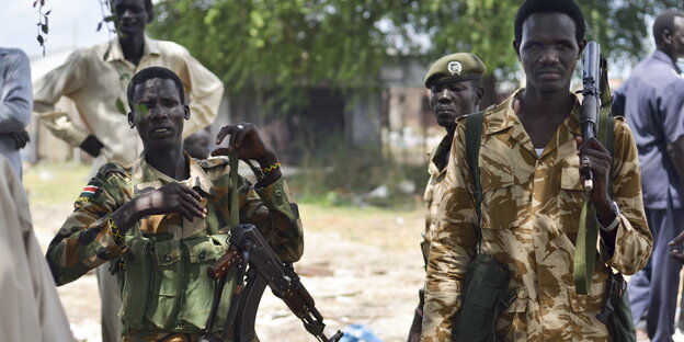 Sudanesische Soldaten tragen Gewehre Sudanesische Soldaten tragen Gewehre