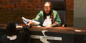 Die südafrikanische Richterin Sisi Khampepe mit langen eng am Kopf anliegenden geflochtenen Haaren übergibt nach Urteilsverkündung die Akte an einer Gerichtsmitarbeiterin