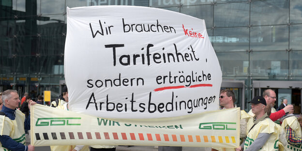 Demonstranten protestieren mit einem großen Transparent: "Wir brauchen keine Tarifeinheit, sondern erträgliche Arbeitsbedingungen." Demonstranten protestieren mit einem großen Transparent: "Wir brauchen keine Tarifeinheit, sondern erträgliche Arbeitsbedingungen."