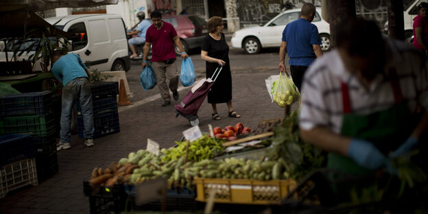 Eine Frau kauft auf einem Markt in Athen ein Eine Frau kauft auf einem Markt in Athen ein