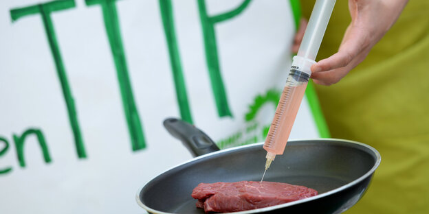 Eine Spritze steckt in einem Steak. Eine Spritze steckt in einem Steak.