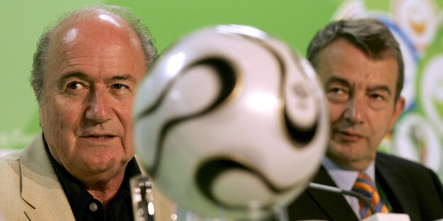 Sepp Blatter und Wolfgang Niersbach rechts und links von einem Fußball. Sepp Blatter und Wolfgang Niersbach rechts und links von einem Fußball.