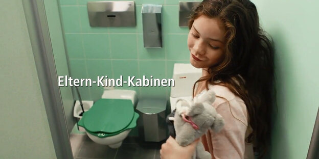 Ein Mädchen geht in eine Toiletten-Kabine. Ein Mädchen geht in eine Toiletten-Kabine.