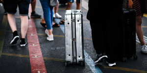Ein Rollkoffer auf einem überfüllten Bahnsteig