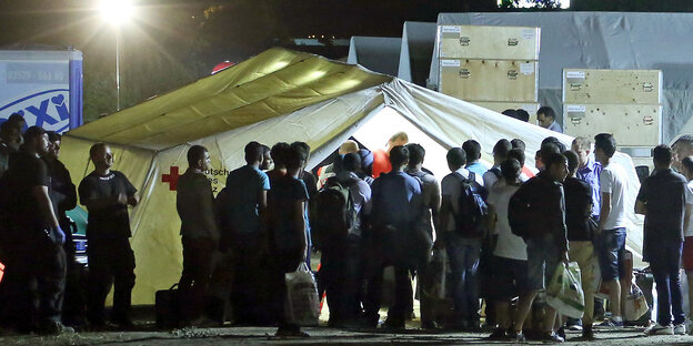Flüchtlinge kommen in einer Zeltstadt an Flüchtlinge kommen in einer Zeltstadt an