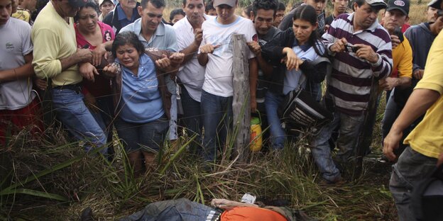 2012 in Curuguaty: Landlose stehen um die Leiche eines erschossenen Compañeros. 2012 in Curuguaty: Landlose stehen um die Leiche eines erschossenen Compañeros.