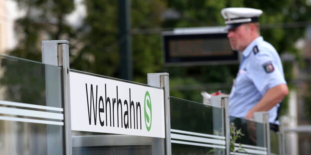 Ein Polizist lehnt an der S-Bahn-Station Wehrhahn Ein Polizist lehnt an der S-Bahn-Station Wehrhahn