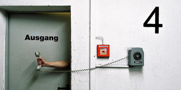 Ein Mann hält hinter einer Tür versteckt einen Telefonhörer in der Hand, man sieht nur den Arm des Mannes Ein Mann hält hinter einer Tür versteckt einen Telefonhörer in der Hand, man sieht nur den Arm des Mannes