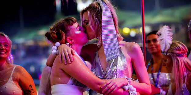 Zwei Frauen in Sommerkleidern küssen sich