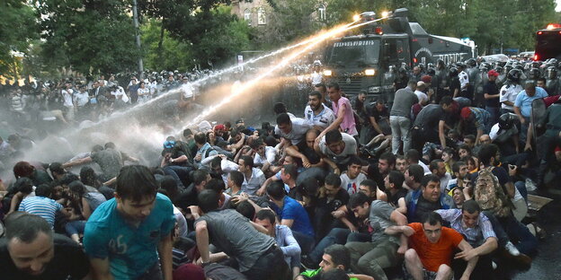 Demonstranten in Jerewan im Strahl eines Wasserwerfers