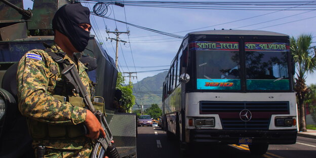 Ein Soldat steht neben einem Bus Ein Soldat steht neben einem Bus
