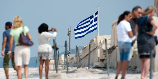Eine griechische Fahne flattert am Strand