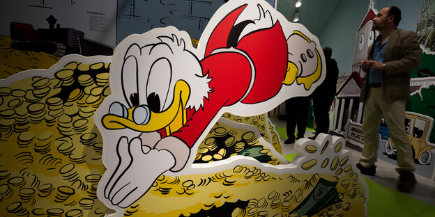 Ein Bild von Dagobert Duck, der in einen Speicher voll Gold taucht Ein Bild von Dagobert Duck, der in einen Speicher voll Gold taucht