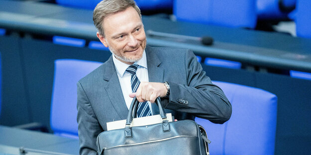 Finanzminister Lindner mit Tasche im Bundestag.