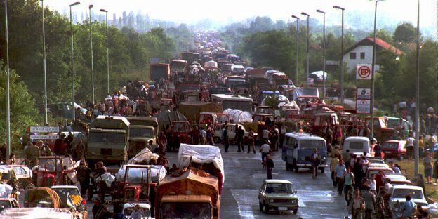 Eine Straße ist gefüllt von Menschen und Autos Eine Straße ist gefüllt von Menschen und Autos