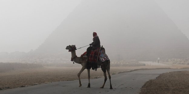 Reiter auf einem Kamel vor einer Pyramide