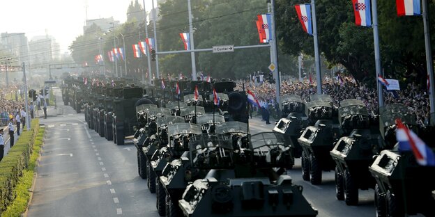 viele Panzer hintereinander auf einer festlich geschmückten Straße viele Panzer hintereinander auf einer festlich geschmückten Straße