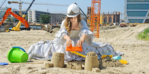 Eine Frau sitzt im Sand Eine Frau sitzt im Sand