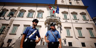 Polizisten stehen Wache vor einem beigefarbenen Palast