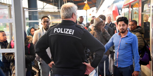 Ein Beamter der Bundespolizei kontrolliert Reisende auf dem Bahnsteig Ein Beamter der Bundespolizei kontrolliert Reisende auf dem Bahnsteig