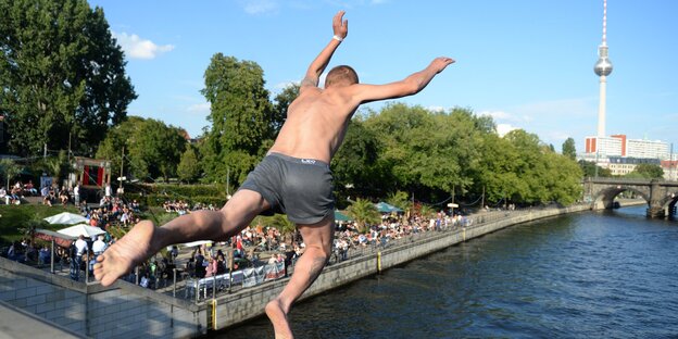 Ein Mann springt in die Spree