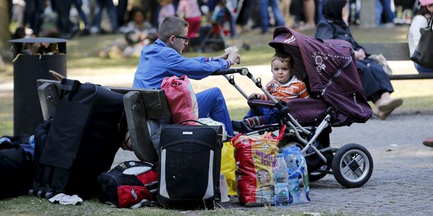 Ein Junge sitzt vor einem Kind in Kinderwagen Ein Junge sitzt vor einem Kind in Kinderwagen