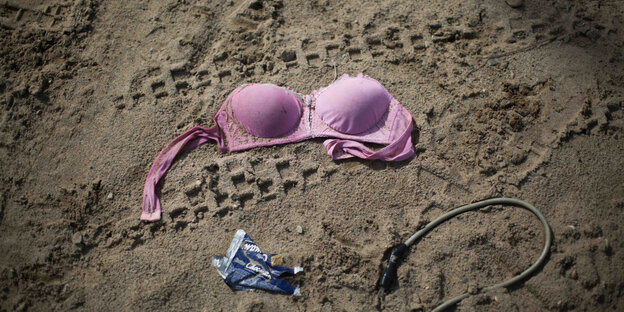Ein pinker BH liegt nach einer Razzia im Sand Ein pinker BH liegt nach einer Razzia im Sand