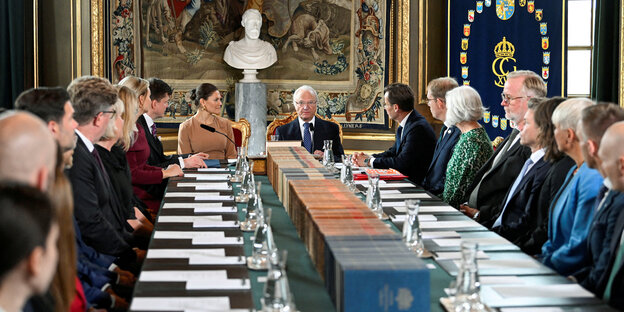 Prinzessin Viktoria und ihr Vater Karl Gustav von Schweden sitzen am Kopfende eines langen Tisches, an dem die neuen Regierungsmitglieder Platz genommen haben