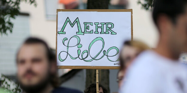Demonstranten halten ein Schild hoch, auf dem „Mehr Liebe“ steht. Demonstranten halten ein Schild hoch, auf dem „Mehr Liebe“ steht.