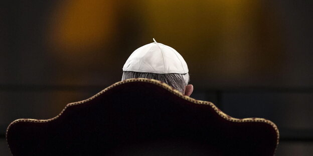 Papst Franziskus sitzt mit dem Rücken zur Kamera Papst Franziskus sitzt mit dem Rücken zur Kamera