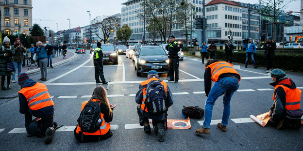 Aktivisten der Klimaschutz-Initiative Letzte Generation· kleben sich am Stachus in München mit ihren Händen auf der Straße fest