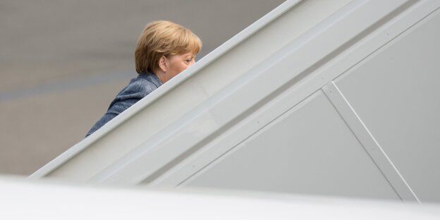 Angela Merkel verschwindet hinter einer Mauer Angela Merkel verschwindet hinter einer Mauer