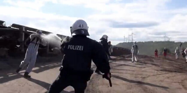 Polizist sprüht mit Pfefferspray einen Demonstranten an Polizist sprüht mit Pfefferspray einen Demonstranten an