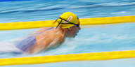 Brustschwimmerin zwischen zwei gelben Bahnmarkierungen